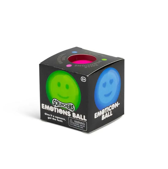 Eine schwarze Schachtel mit der Aufschrift „Emotions Squish Ball“ von www.buyon.at zeigt auf verschiedenen Seiten ein grünes und ein blaues Smiley-Gesicht. Durch ein ausgeschnittenes Fenster ist ein hellgrüner Squish-Ball im Inneren zu sehen. Auf der Schachtel steht „Drücken Sie, um die Gefühle zu erleben“ und am unteren Rand befindet sich ein Warnhinweis.