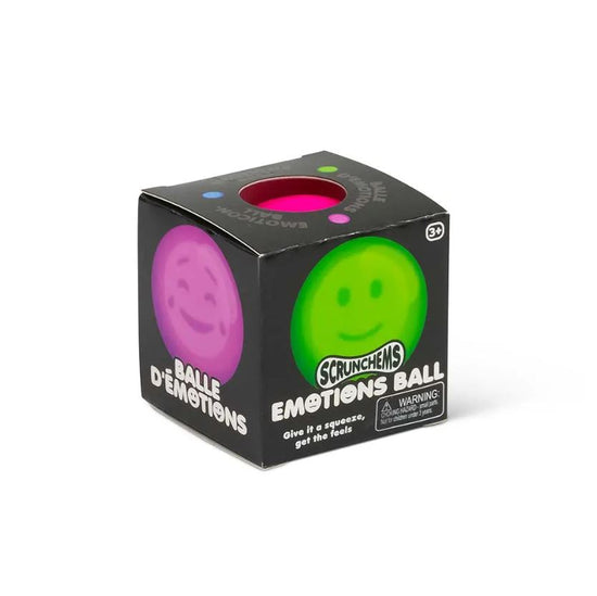 Eine würfelförmige Schachtel mit der Aufschrift „www.buyon.at Emotions Squish Ball“ enthält einen rosa-grünen Quetschball mit Smileys. Auf der Verpackung steht „Balle d'émotions“ und „Drücken Sie, um die Gefühle zu spüren“. Ideal für Kinder ab 3 Jahren, perfekt zur sensorischen Stimulation.