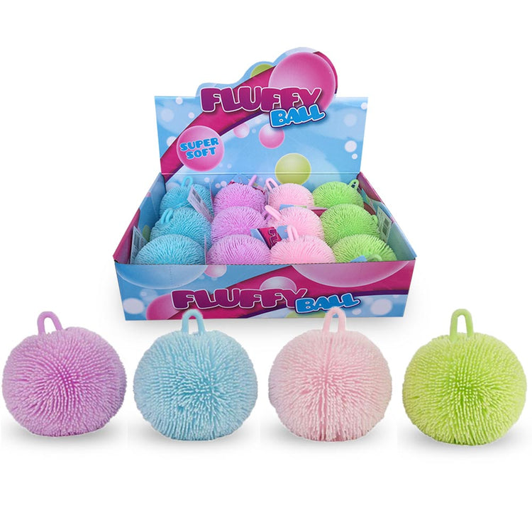 Eine Displaybox mit flauschigen Bällen mit der Aufschrift „FLUFFY QUETSCHBALL PASTELL“, die verschiedene Pastellfarben wie Lila, Blau, Rosa und Grün zeigt. Vier Fluffy Quetschbälle dieser Farben sind vor der Box aufgereiht. Der Text auf der Box lautet „Super Soft“ und verspricht Entspannung und die Verbesserung der Feinmotorik.