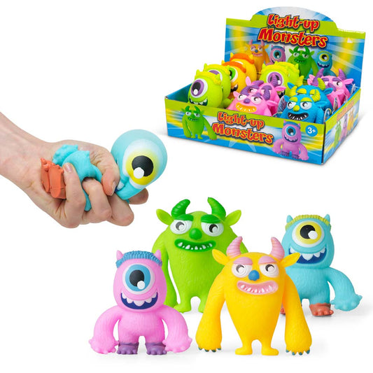 Eine Ausstellung farbenfroher, cartoonhafter Squeeze Light Up Monster von www.buyon.at. Ein blaues Squeeze Light Up Monster mit einem großen Auge wird links in einer Hand zusammengedrückt. Vier leuchtende Monster – rosa, grün, gelb und blau – mit unterschiedlichen Gesichtszügen und Ausdrücken stehen vor der Ausstellungsbox.