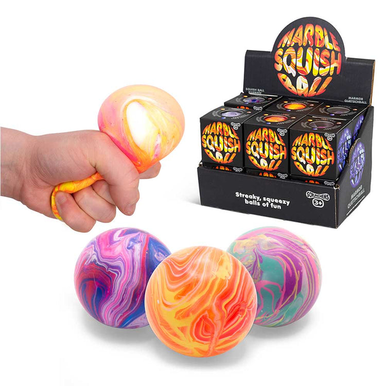 Eine Hand drückt einen Marble Squish Ball von www.buyon.at, dessen Außenseite mehrfarbig und die Innenseite weiß ist und der somit eine angenehme taktile Stimulation bietet. Darunter sind drei ähnliche Bälle in verschiedenen wirbelnden Farben zu sehen, die den faszinierenden Marmoreffekt hervorheben. Im Hintergrund enthält eine Displaybox mit der Aufschrift „Marble Squish Ball“ mehrere verpackte Squish-Bälle.