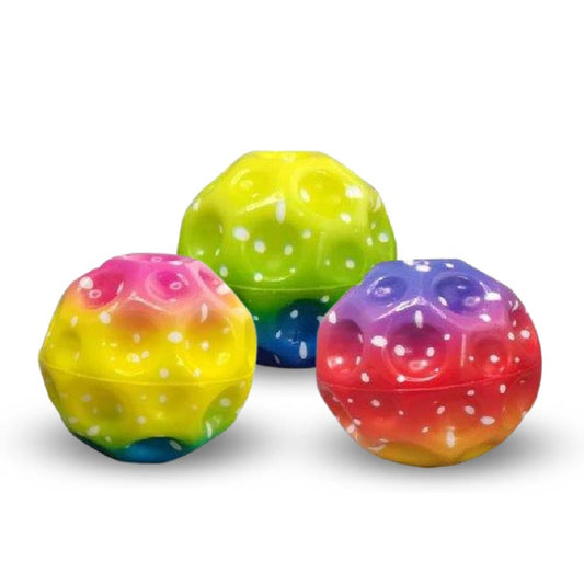 Drei farbenfrohe, holprige, kugelförmige Mega High-Bounce-Bälle von www.buyon.at werden ausgestellt. Jeder Ball der Rainbow Edition weist einen auffälligen Farbverlauf mit einem Muster aus weißen Punkten auf. Die Farben umfassen Gelb-, Grün-, Rosa-, Blau- und Lilatöne und die Oberflächenstruktur weist unregelmäßige Vertiefungen auf. Perfektes Spielzeug für Kinder!