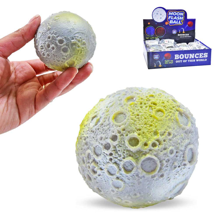 Eine Hand hält einen grau-gelben, holprigen Mondball, der an den Mond erinnert. Unter der Hand ist eine größere Ansicht des Balls zu sehen. Im Hintergrund präsentiert eine Schachtel mit der Aufschrift „Mondball, Bounce Ball mit LED“ mehrere dieser Zappelspielzeuge von www.buyon.at mit dem Slogan „Bounces Out of This World“.