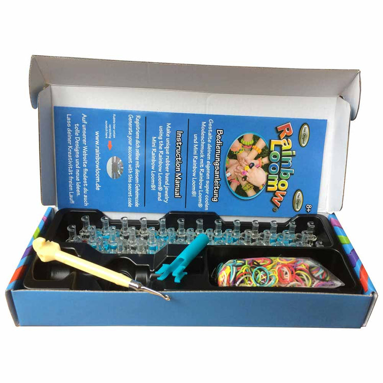 Abgebildet ist ein geöffnetes Original Rainbow Loom Starter-Set von www.buyon.at. Das Set enthält einen Webstuhl, verschiedenfarbige Gummibänder, ein Hakenwerkzeug und eine Bedienungsanleitung. Die Box ist blau mit bunten Akzenten und der Inhalt ist übersichtlich darin angeordnet.