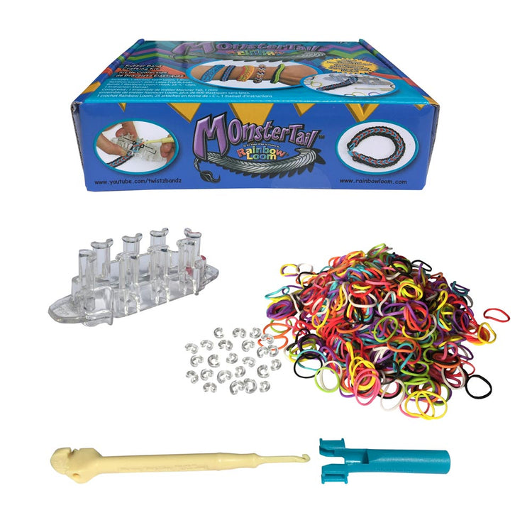 Das Original Rainbow Loom® Monster Tail™-Kit von www.buyon.at enthält einen durchsichtigen Webstuhl, ein gelbes Hakenwerkzeug, einen blauen Mini-Webstuhl, einen Stapel Rainbow Loom Gummibänder und mehrere durchsichtige Plastikklammern. Verpackt in einer blau-weißen Schachtel mit der Aufschrift „Monster Tail von Rainbow Loom“ bietet dieses Kit auch Anleitungen, die auf YouTube verfügbar sind.