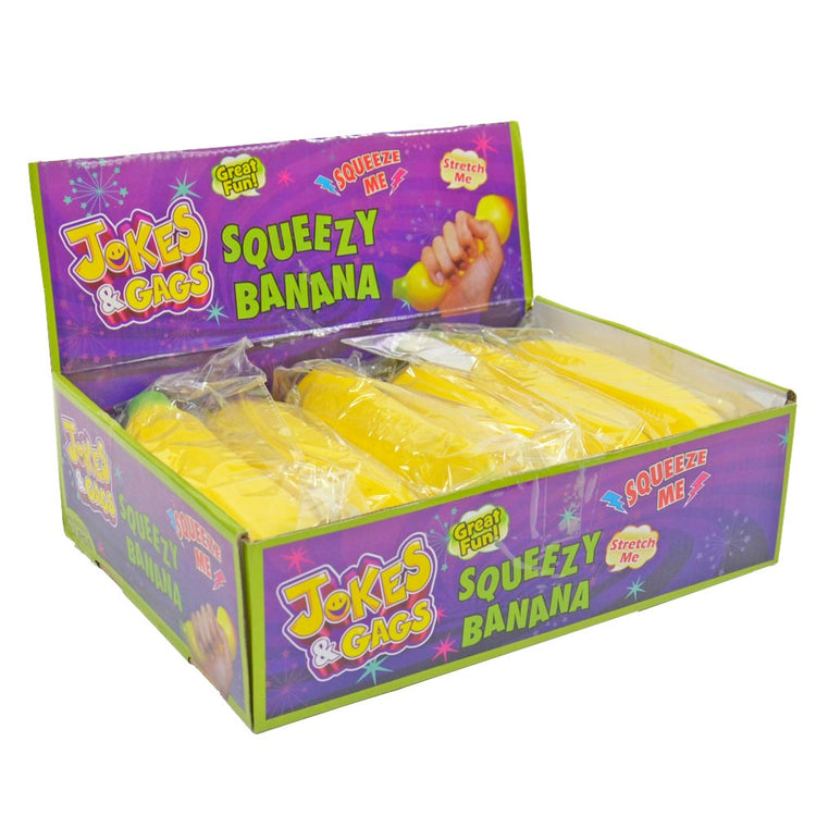 Eine Displaybox mit der Aufschrift „Jokes & Gags“ enthält mehrere gelbe Squeeze Banane-Spielzeuge von www.buyon.at. Auf der Verpackung sind die Aufschriften „Great Fun“, „Stretch Me“ und „Squeeze Me“ zu sehen, ideal zum Stressabbau. Die farbenfrohe Displaybox mit verspielten Grafiken macht sie zum perfekten Spielzeug für Kinder.