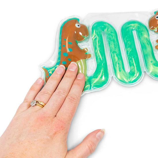 Eine mit zwei Ringen geschmückte Hand drückt auf das Sensorik Spielzeug Maze, Dinos von www.buyon.at. Das transparente Pad, gefüllt mit grünem Gel und geformt in einem verschnörkelten Linienmuster, zeigt an einem Ende einen verspielten braunen Cartoon-Dinosaurier für ein vergnügliches taktiles Spiel mit Dinosauriermotiv.