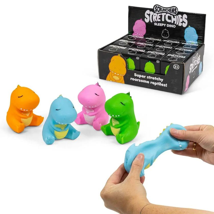 Vier farbenfrohe und dehnbare Dinosaurierspielzeuge in Orange, Lila, Rosa und Blau werden vor einer Schachtel mit der Aufschrift „Stretchy Sleepy Dino“ von www.buyon.at ausgestellt. Eine Person dehnt das blaue Dinosaurierspielzeug, indem sie an den Enden zieht. Dieses einzigartige Spielzeug dient auch als stressabbauendes Spielzeug.